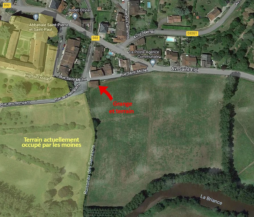 Vue satellite annotée du bourg de Solignac, en France. Au nord-ouest, l'Abbatiale Saint-Pierre et Saint-Paul est visible. Une flèche rouge pointe vers une « Grange et terrain », située à l'intersection de la rue Saint-Michel et du Ruisseau des Sarrazins. Juste à l'ouest de ce cours d'eau, une zone plus claire est désignée par le texte « Terrain actuellement occupé par les moines ». La rivière La Briance coule au sud, bordée d'arbres. Plusieurs axes routiers, dont la D32 et l'Avenue Saint-Eloi, traversent la zone urbaine au nord.