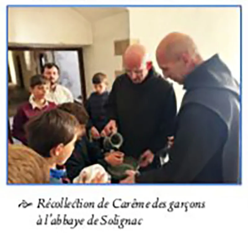 Moines en habit sombre entourés de jeunes garçons lors d&rsquo;une récollection de Carême à l&rsquo;abbaye de Solignac.